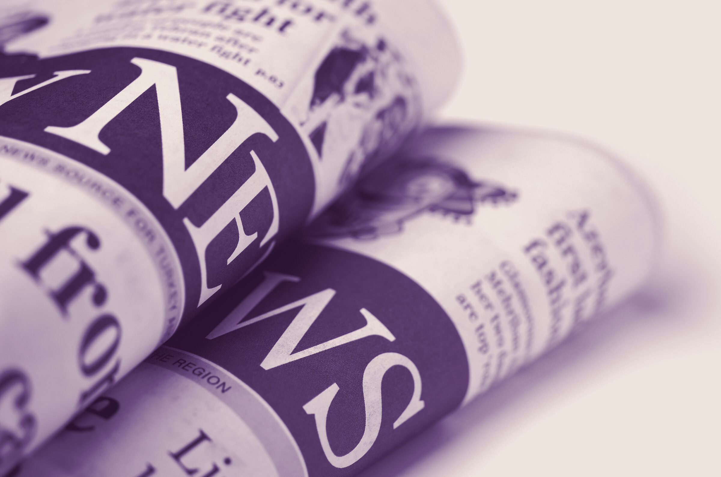 Rolled newspapers stacked in close-up.