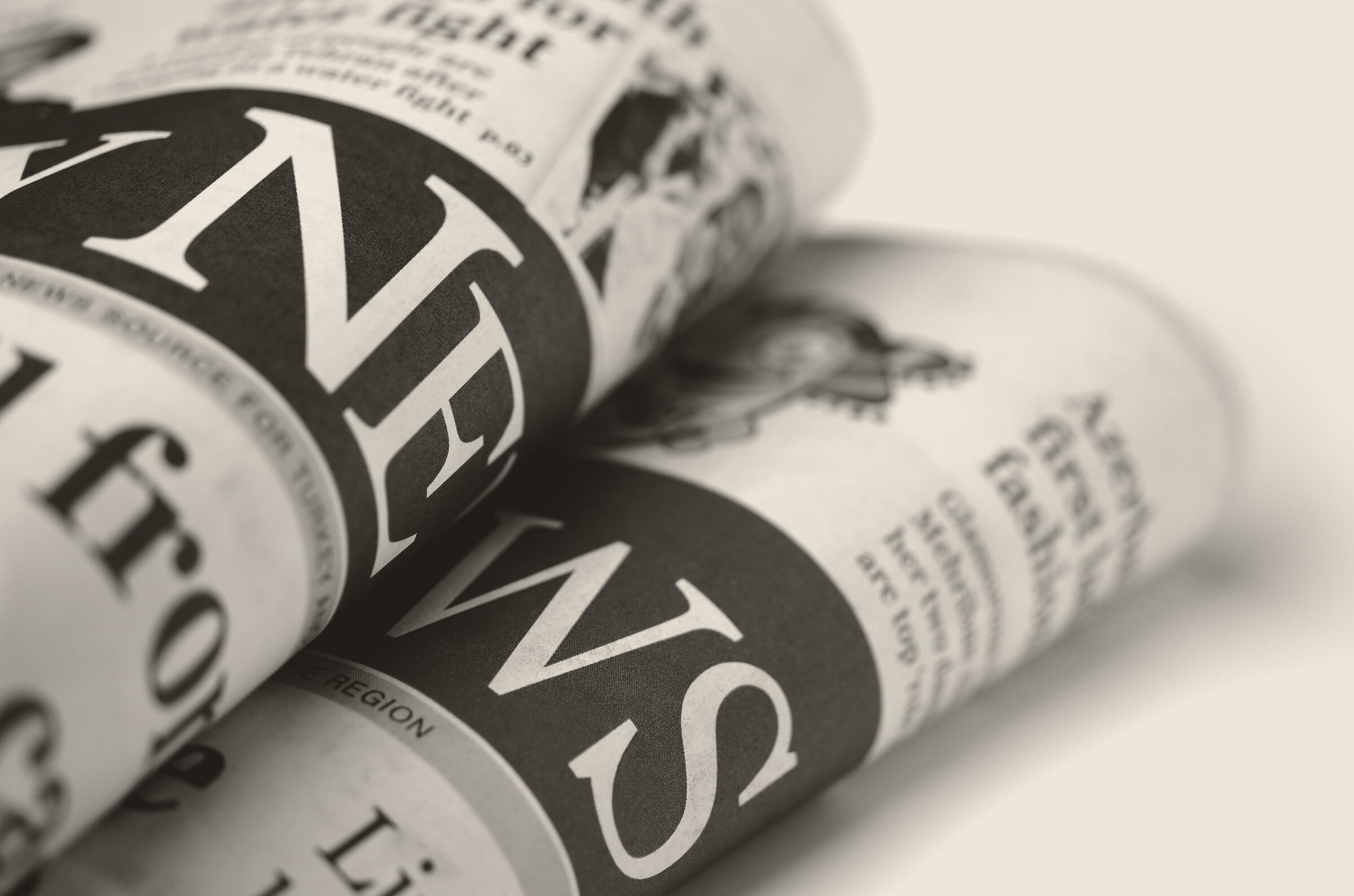 Rolled newspapers stacked in close-up.